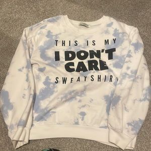 A Tie Dye sweatshirt that says this is my I don’t care sweatshirt.